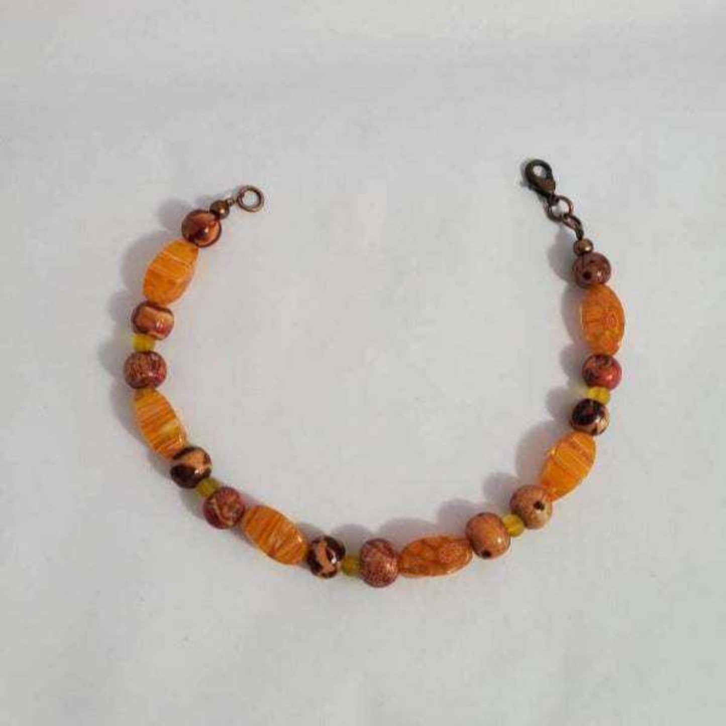 Millefiori Glass Bracelet with orange glass beads, hand-painted wooden accents, and copper clasp, ideal fall fashion accessory
