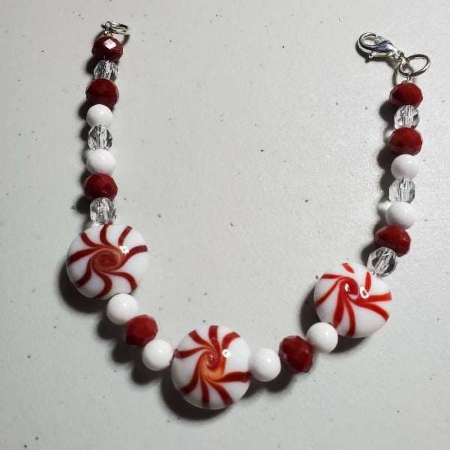 Holiday Bracelet featuring red and white peppermint glass beads with crystal accents and lobster clasp