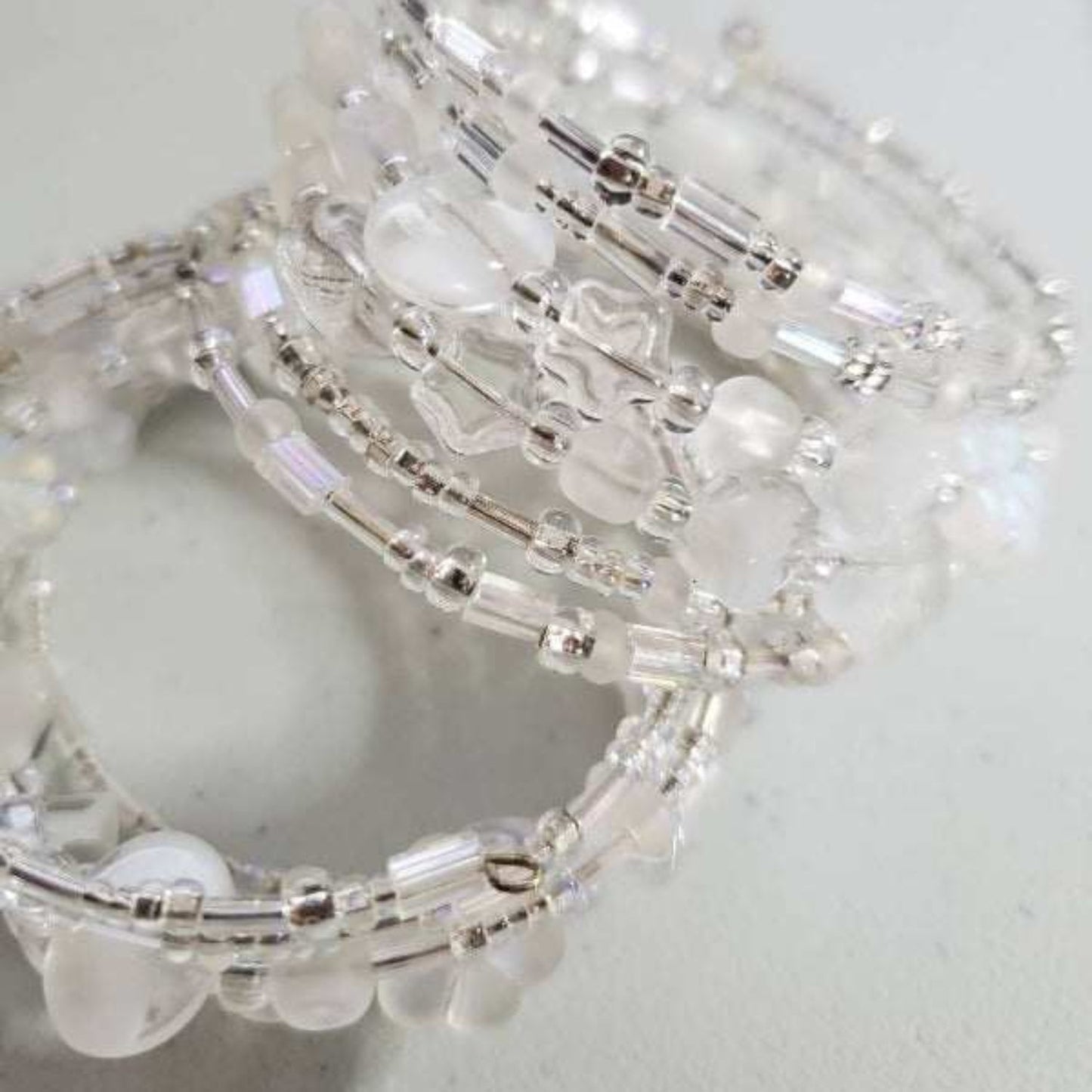 Close-up of an ice crystal cuff bracelet featuring frosty glass and shimmering crystal beads with an adjustable open design