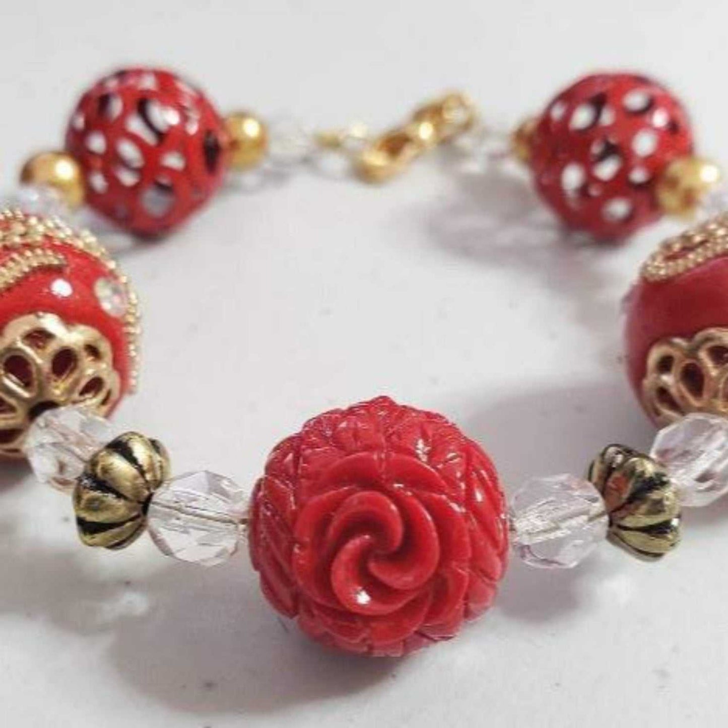 Vintage Style Eastern Spirit Bracelet with red carved beads, brass accents, and crystal details, handmade fashion accessory