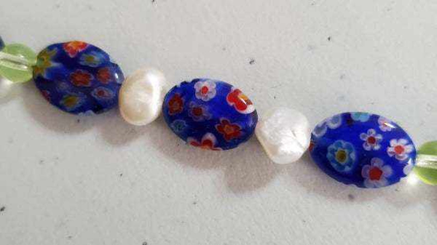 Close-up of blue millefiori beads and white pearls on a handcrafted bracelet