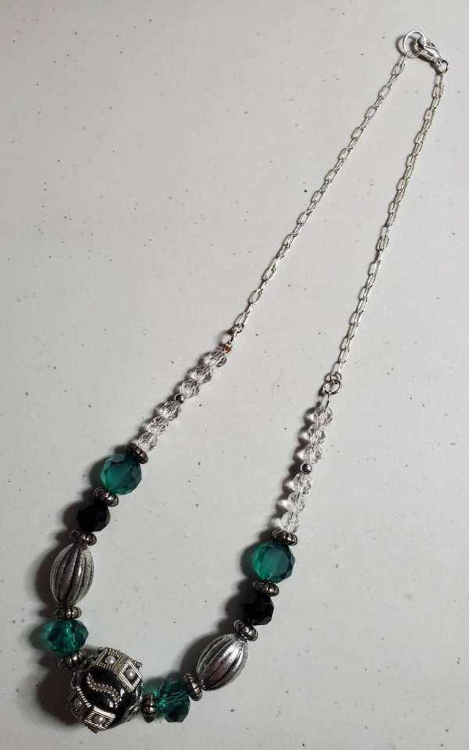 Vintage fashion-inspired statement necklace with teal and black beads and silver accents