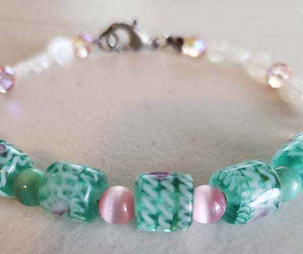 Handcrafted gemstone bracelet with pink and green jade, glass, and cat's eye beads and lobster claw clasp.