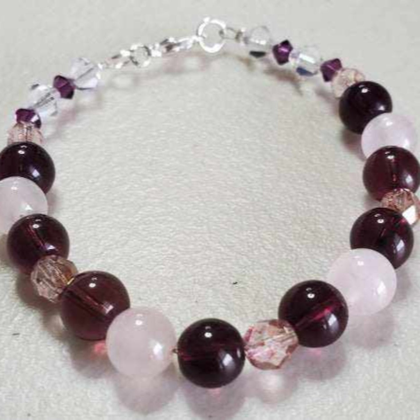 Handcrafted gemstone bracelet with amethyst and rose quartz beads accented by sparkling crystals and a lobster claw clasp