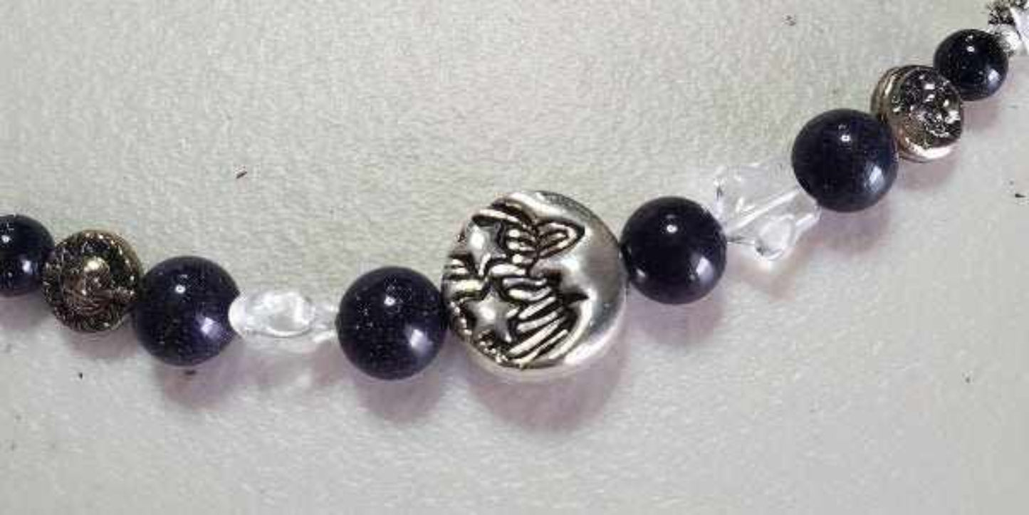 Close-up of Celestial Stars Bracelet featuring blue goldstone beads, lapis lazuli, Czech glass, pewter sun and moon charms, and a star toggle clasp.