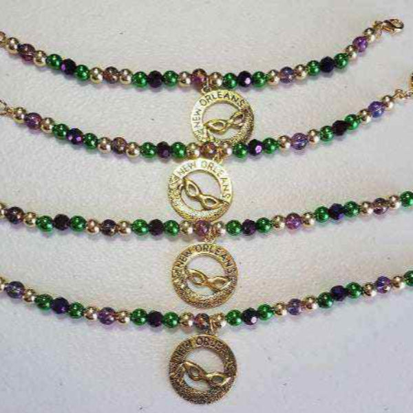 Mardi Gras charm bracelet with purple, green, and gold beads and brass New Orleans mask charm