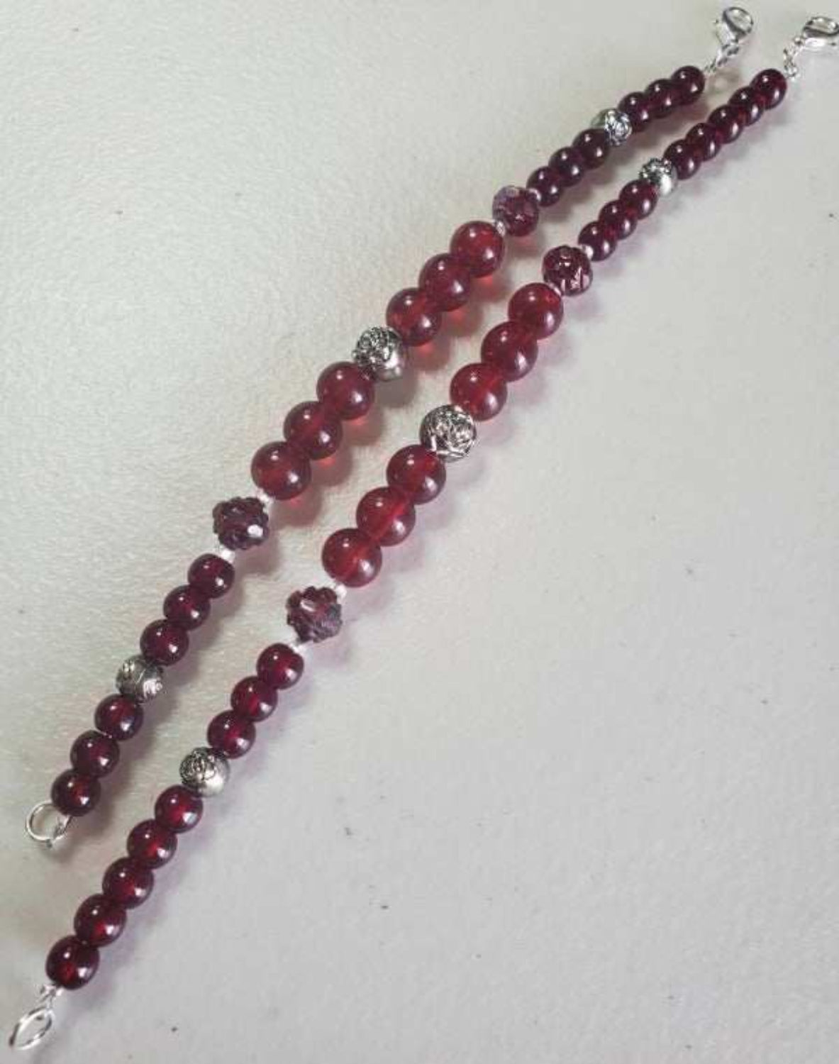 Elegant floral bracelet with garnet-colored glass beads and silver accents, secure lobster claw clasp, 6.5-inch wrist fit