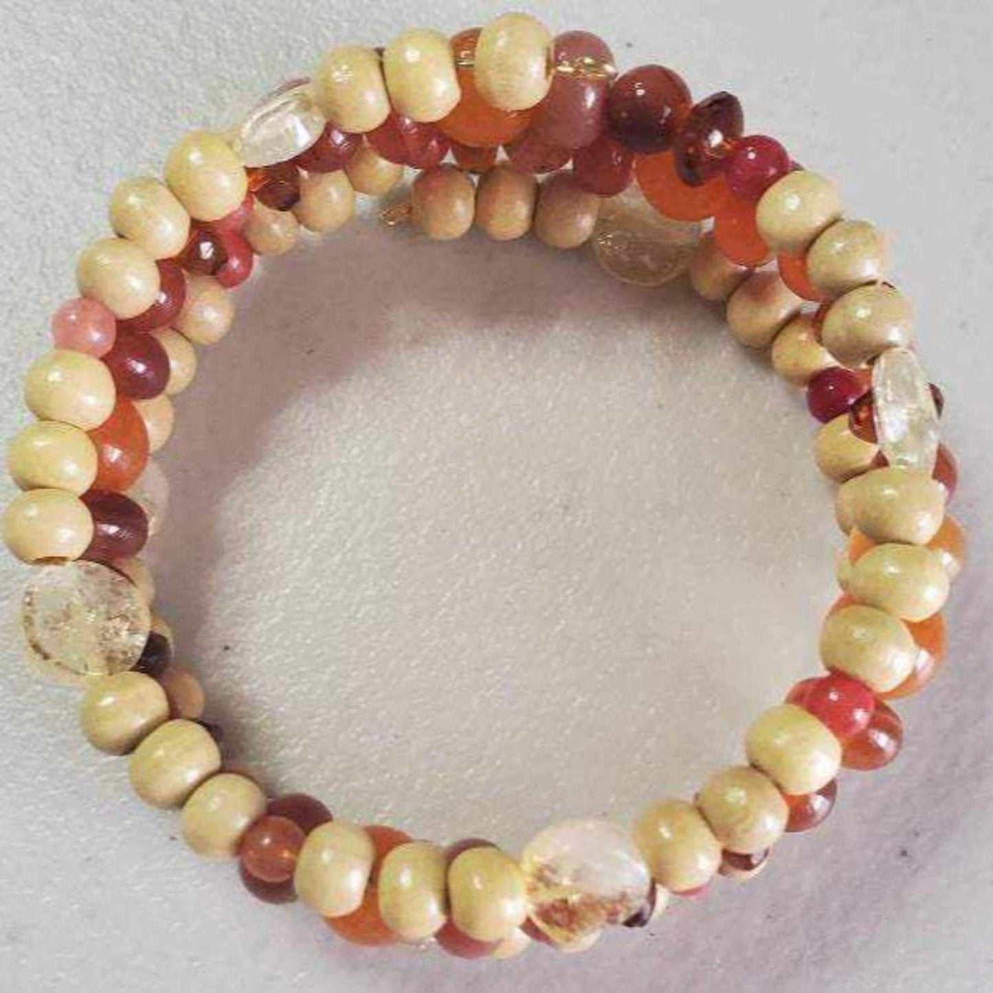 Handcrafted gemstone bracelet featuring carnelian and citrine beads with wood accents in a cuff style.