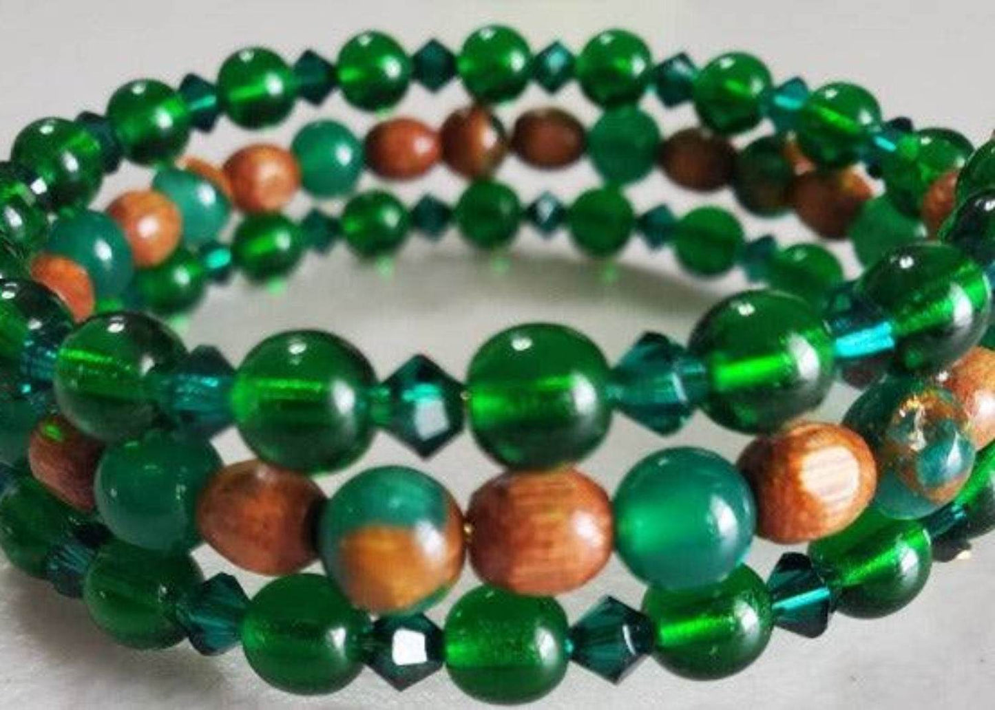 Emerald bracelet with green glass beads and wooden accents on memory wire band