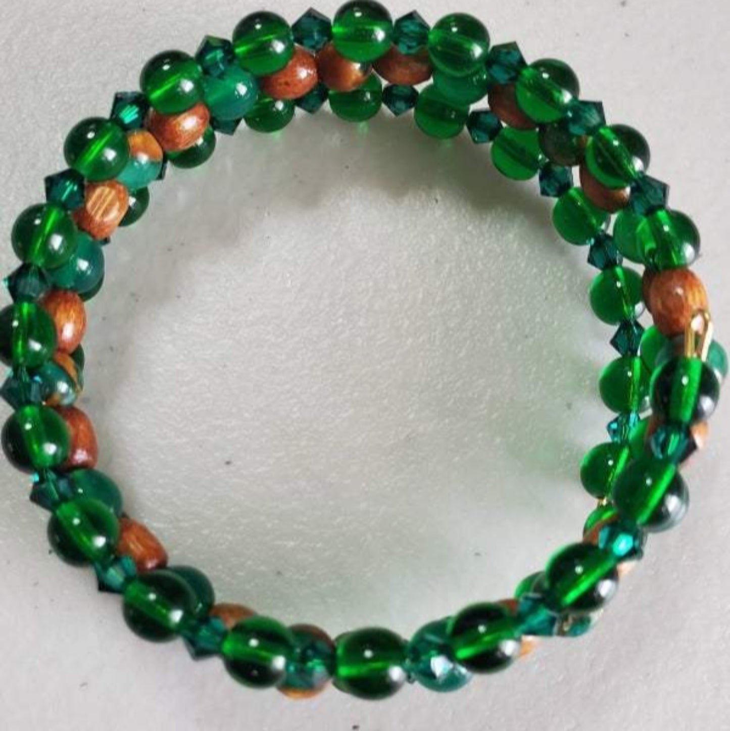 Emerald Cuff Gemstone Bracelet with synthetic emerald, emerald-colored glass, Austrian crystal, and wood beads on adjustable memory wire.