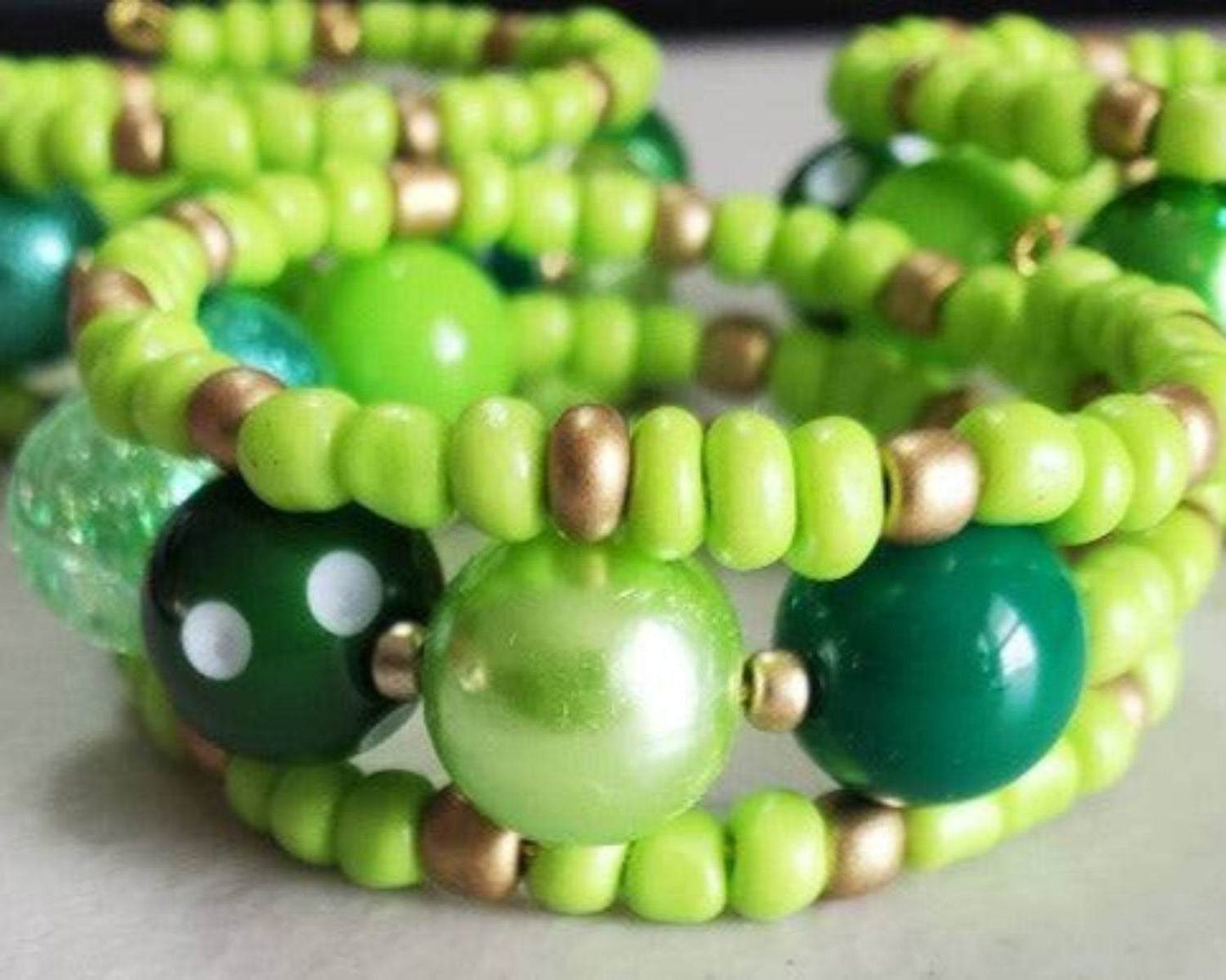 Close-up of Green Gumball Cuff bracelet with vibrant green beads and gold accents on memory wire design