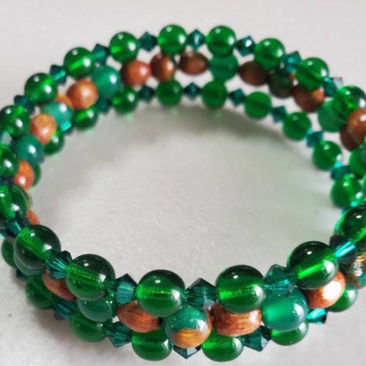 Emerald Cuff Gemstone Bracelet with synthetic emerald and wood beads on adjustable memory wire.