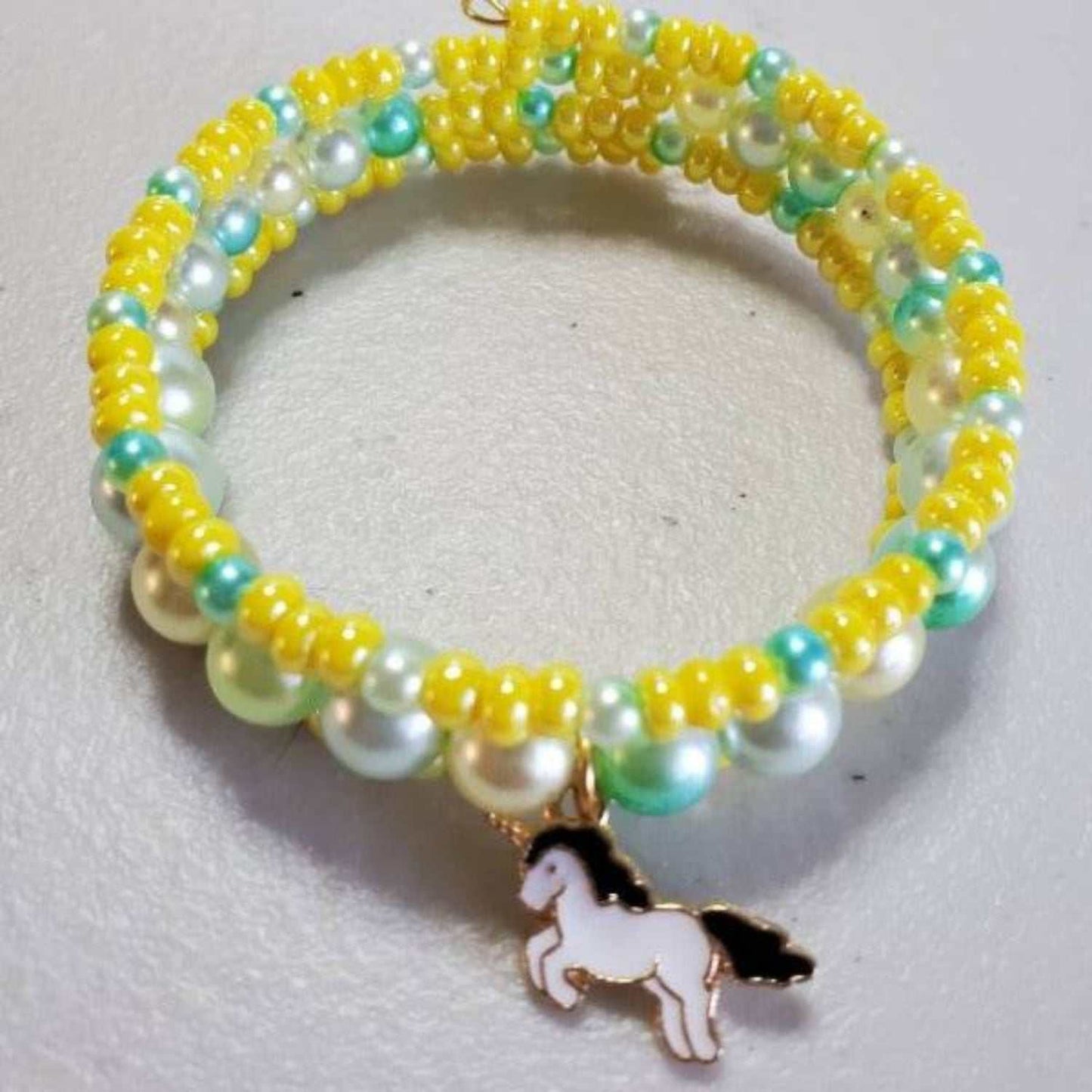 Colorful beaded cuff bracelet with unicorn charm and pearl accents