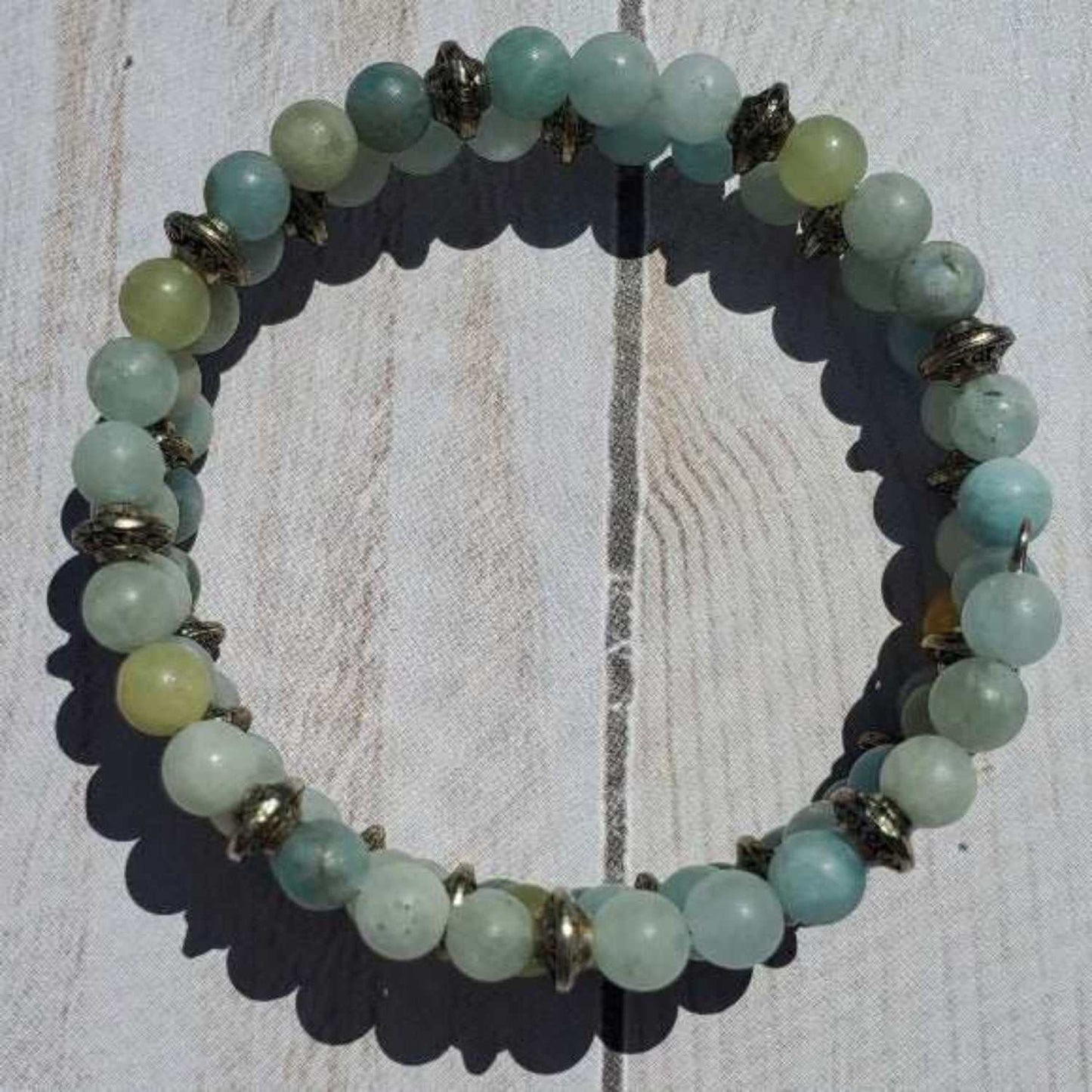 Aquamarine cuff bracelet with genuine aquamarine beads and pewter accents on wooden surface