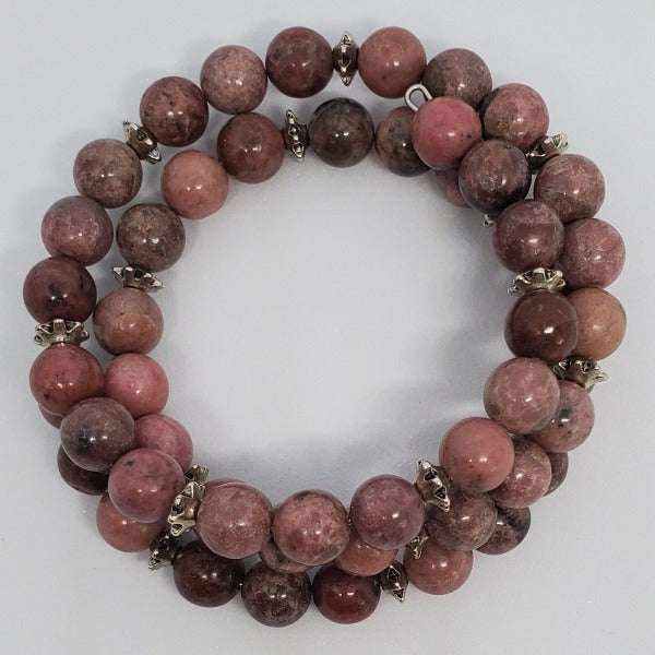 Handcrafted Rhodonite gemstone bracelet with pewter spacers, flexible memory wire cuff in pink and marbled tones for emotional balance and grounding.