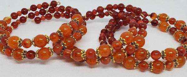Carnelian gemstone bracelet with orange-red beads and brass spacers on flexible memory wire