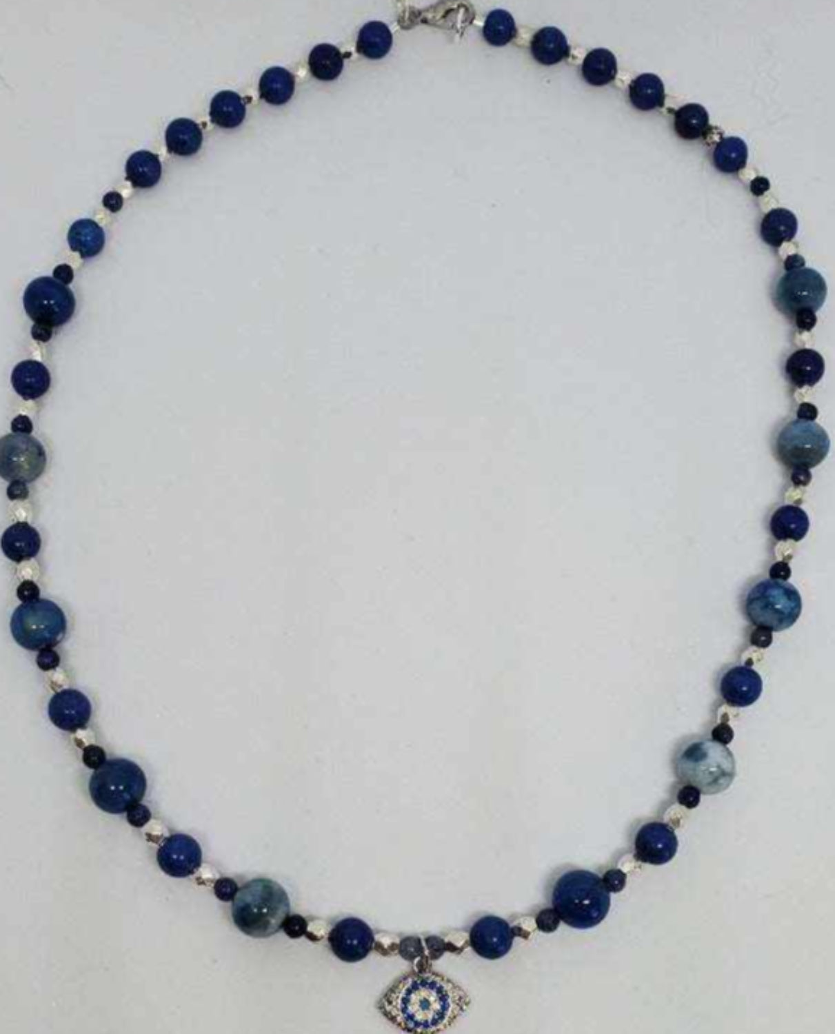 Gemstone necklace with deep blue lapis lazuli beads and rhinestone evil eye pendant for protection and style