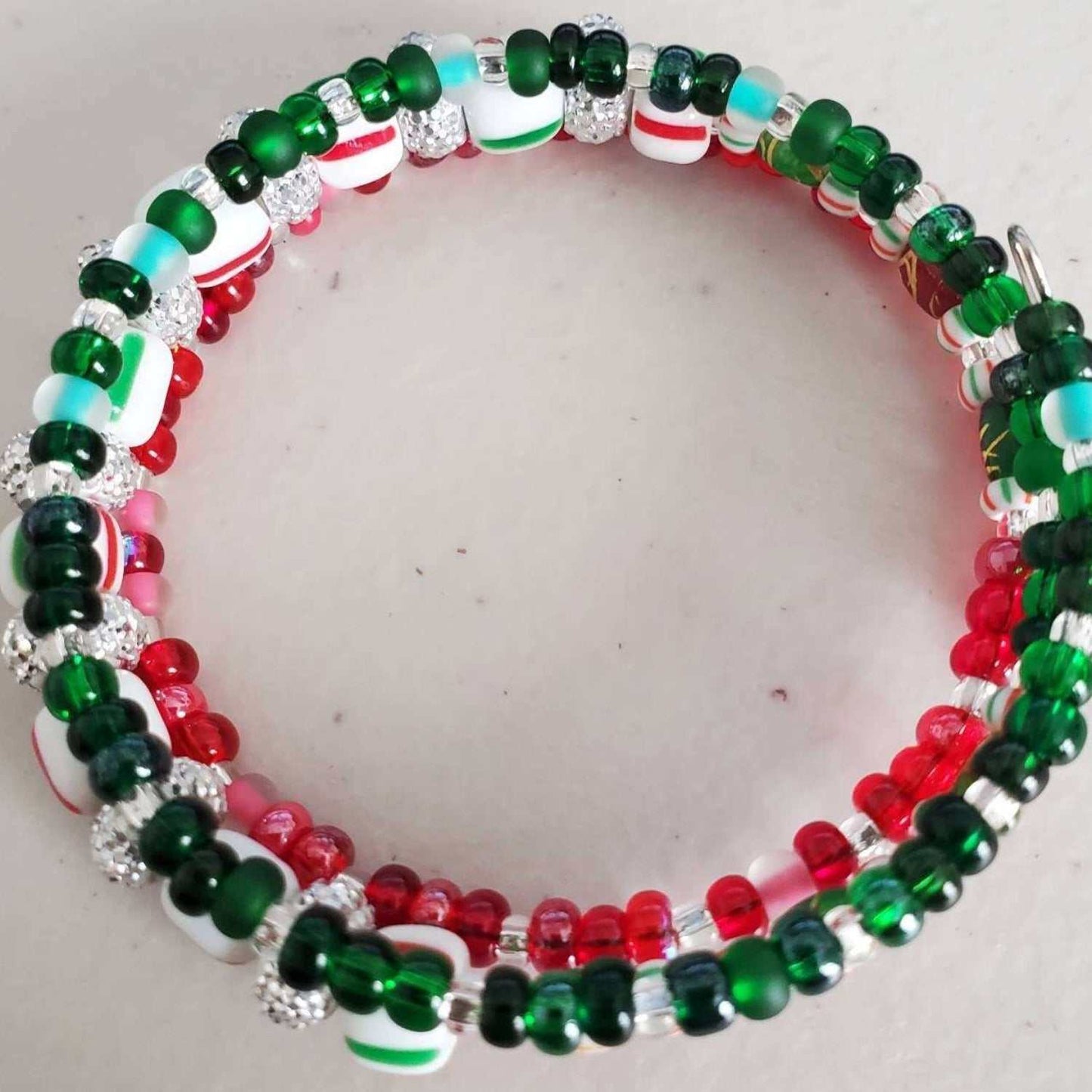 Peppermint Twist Cuff Bracelet with red, green, striped beads and rhinestone accents on memory wire