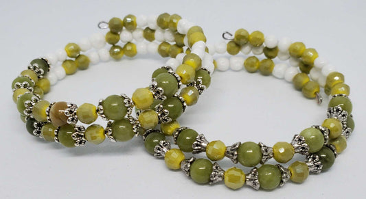 Handcrafted August birthstone bracelet with green peridot and yellow beads accented by silver spacers on white background