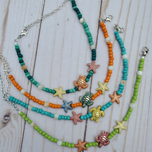 Colorful beaded Anklets with sea-themed charms on a wooden surface