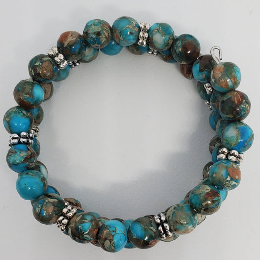 Beaded bracelet with turquoise and brown marbled beads on a white background