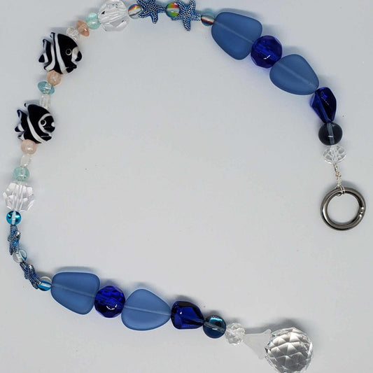 Crystal Suncatcher with blue glass beads, pewter starfish, lampwork fish, sea glass, and a faceted crystal pendant.