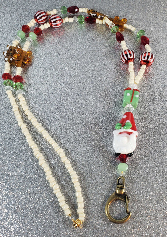 Festive holiday lanyard with glass Christmas gnome, gingerbread men, and colorful beads featuring a brass clasp and magnetic closure.