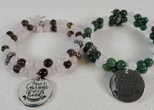 Two gemstone bracelets featuring "Have Courage Be Kind" engraved charms with rose quartz, smoky quartz, green jade, and selenite beads.