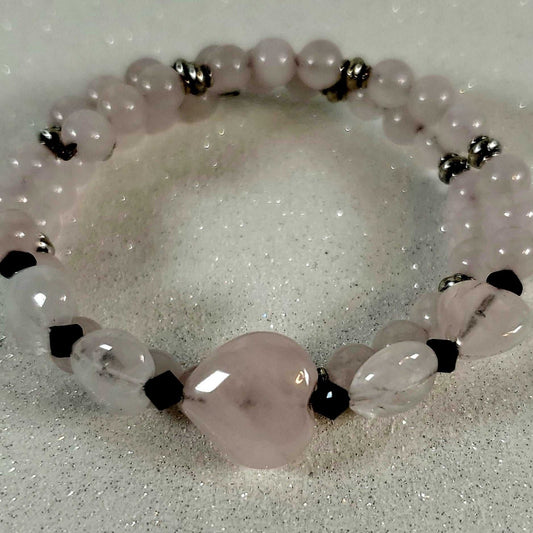 Bracelet with pink beads and black accents on a white background