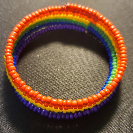 Rainbow-colored cuff bracelet with layered Czech glass seed beads on memory wire, symbolizing inclusion and pride.