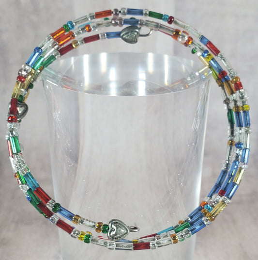 Colorful beaded necklace on a clear stand against a light background