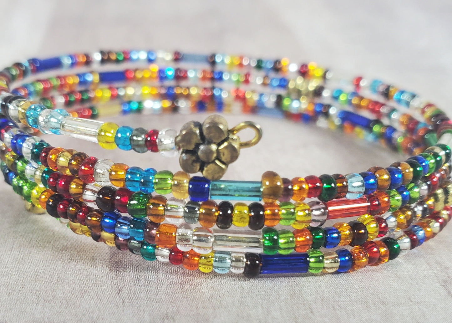 Multicolored beaded bracelet with a gold clasp on a light background