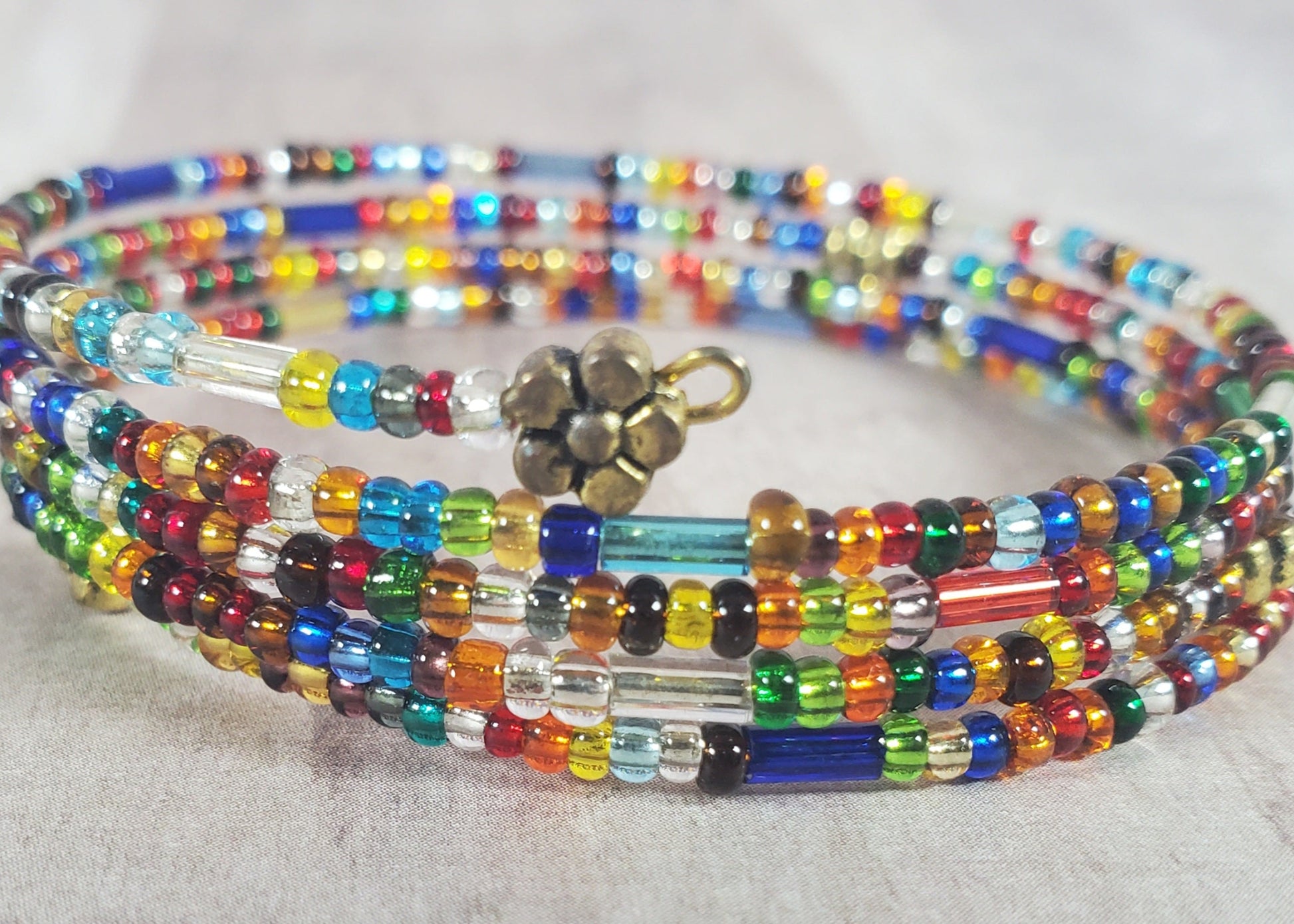 Multicolored beaded bracelet with a gold clasp on a light background