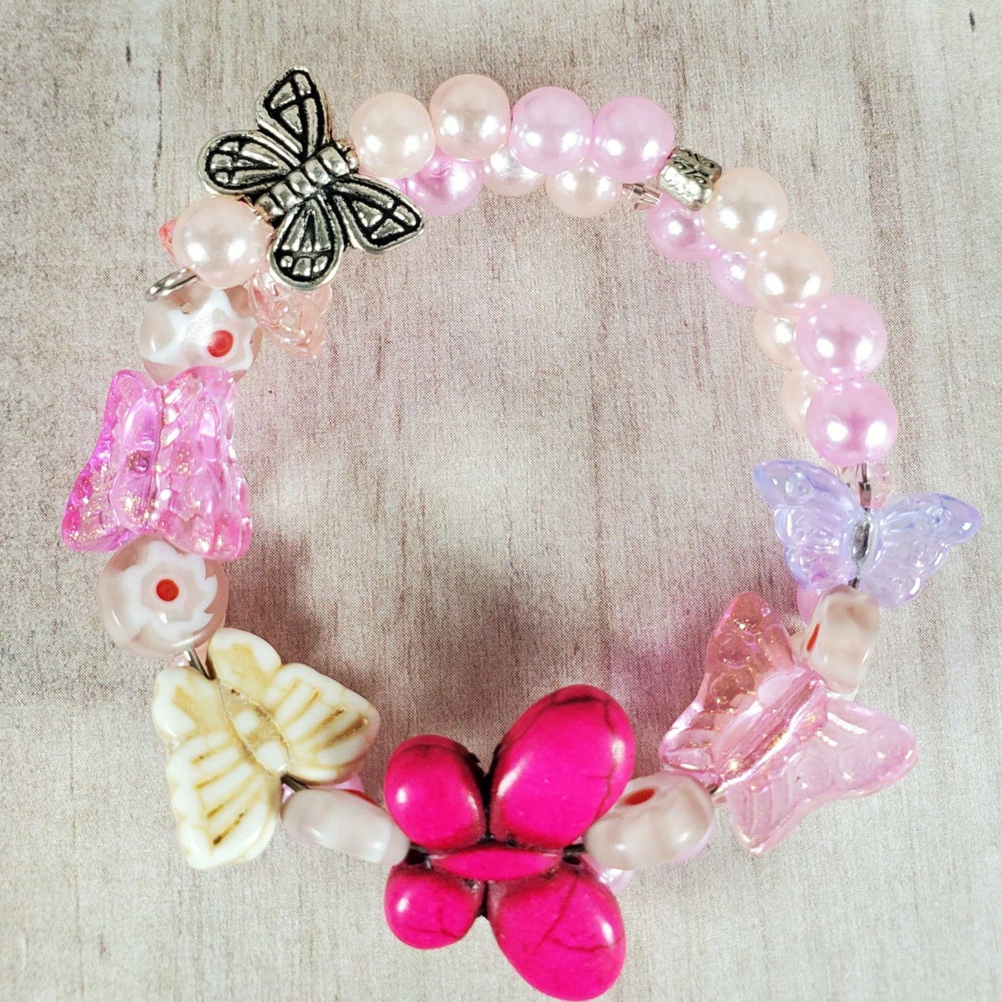 Child's Butterfly Bracelet with colorful butterfly charms, pink and white beads, and flexible memory wire fit.