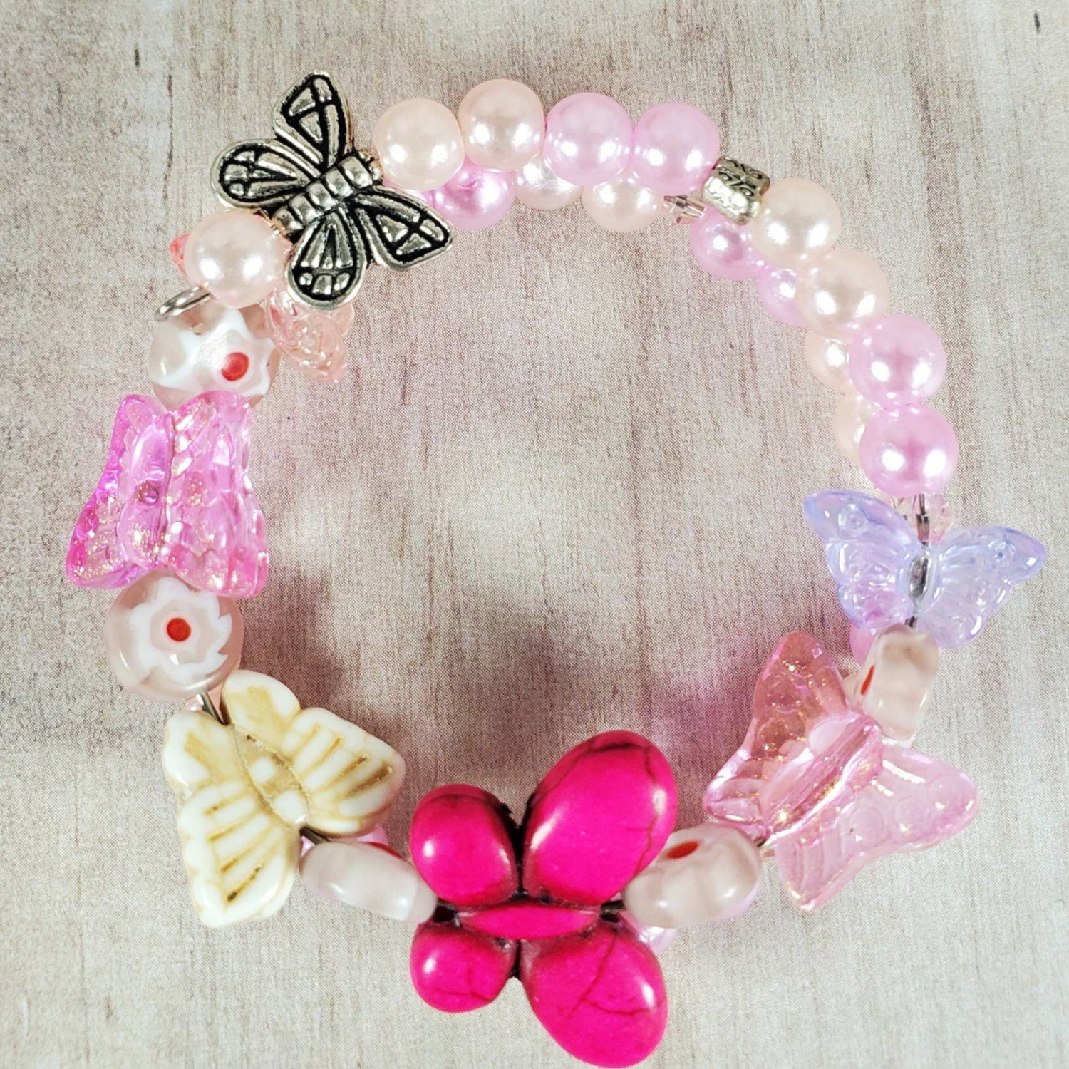Child's Butterfly Bracelet with colorful butterfly charms, pink and white beads, and flexible memory wire fit.
