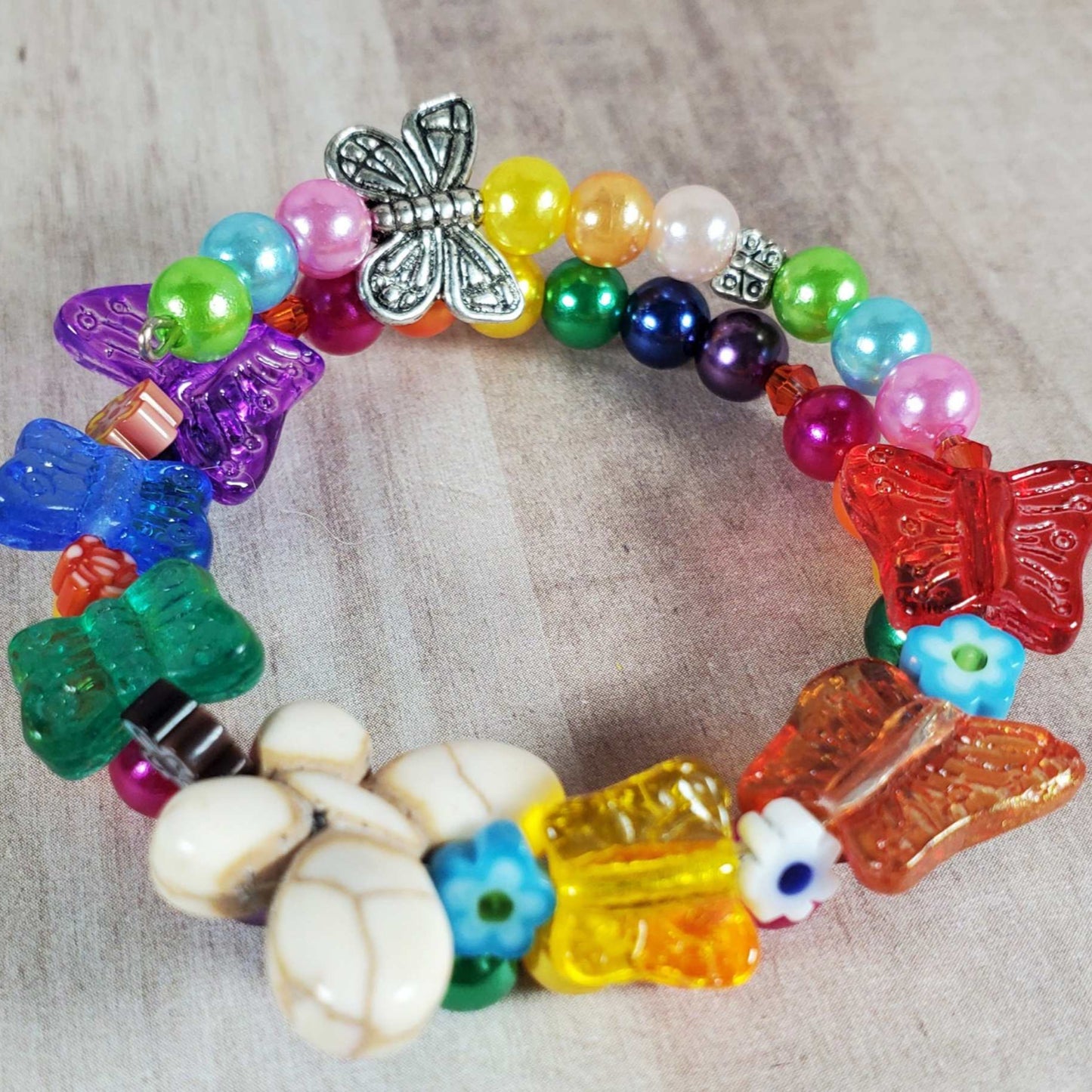 Colorful child's butterfly bracelet with Howlite, glass butterflies, and acrylic pearls on flexible memory wire