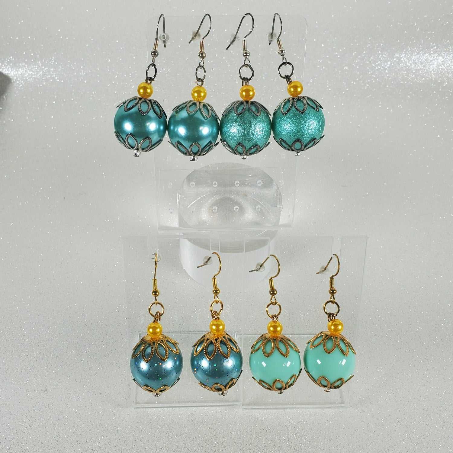 Turquoise beaded earrings with gold accents on a white background