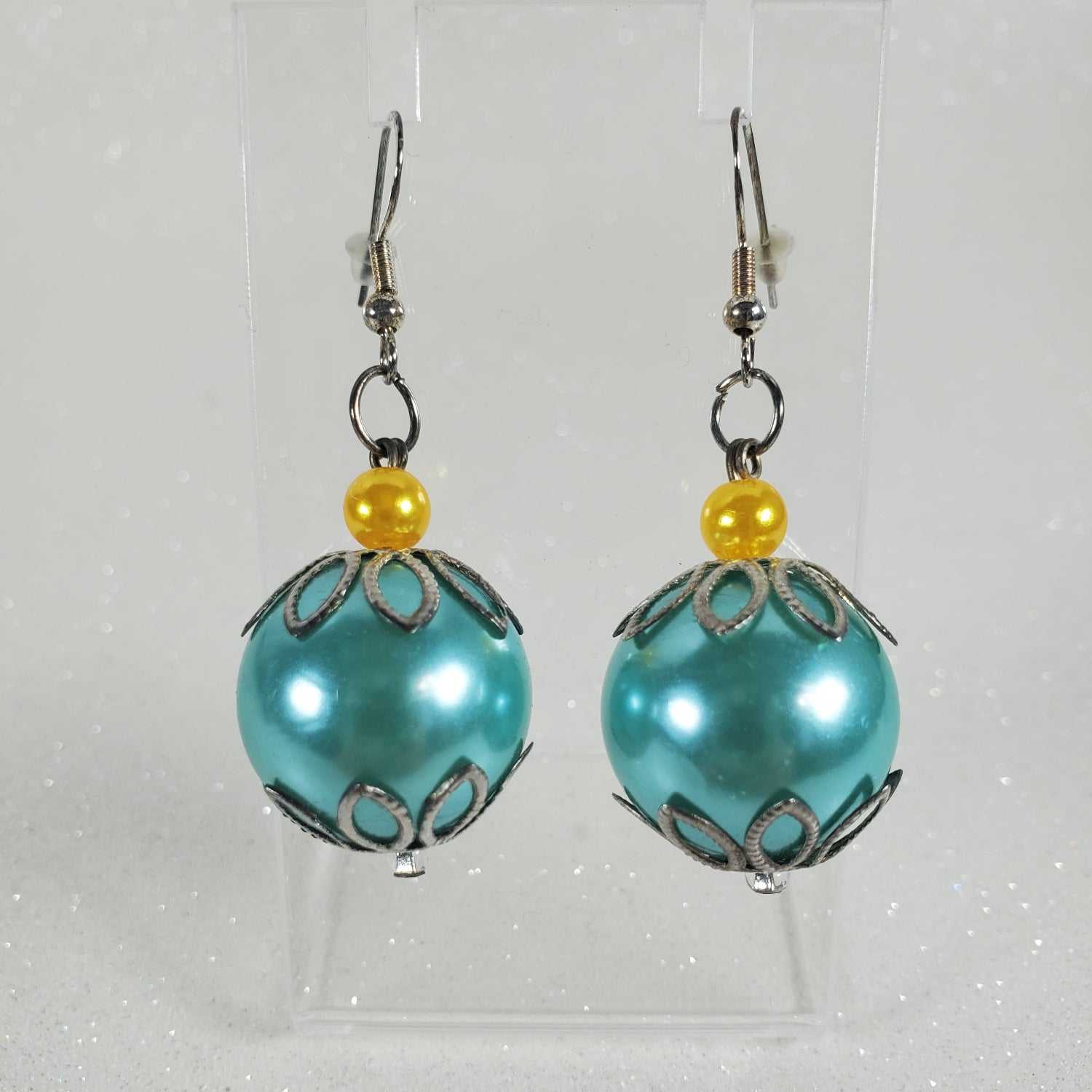 Turquoise earrings with yellow beads on a clear background