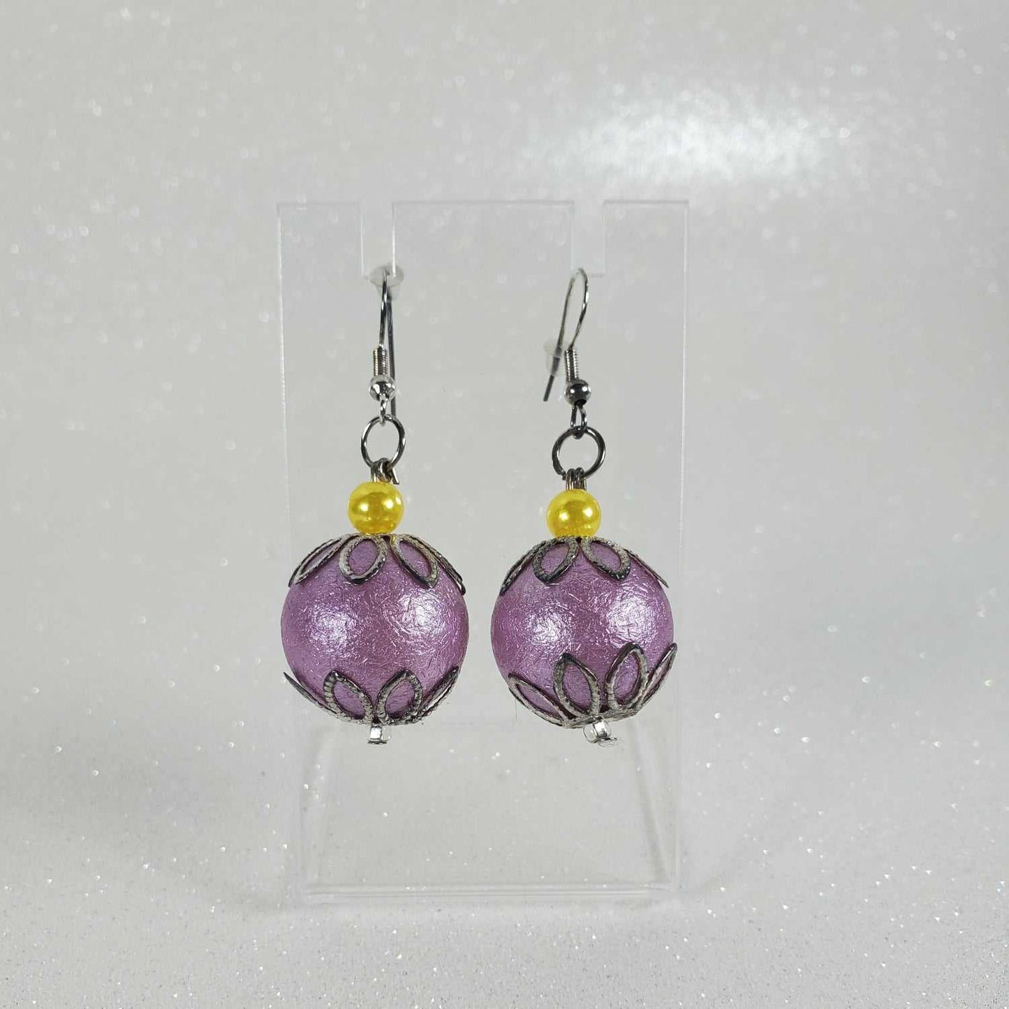 Pair of purple beaded earrings with yellow beads on a white background