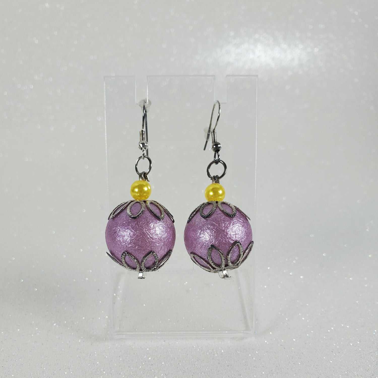 Pair of purple beaded earrings with yellow beads on a white background