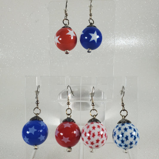 Set of patriotic-themed earrings with red, white, and blue beads on a clear display card.