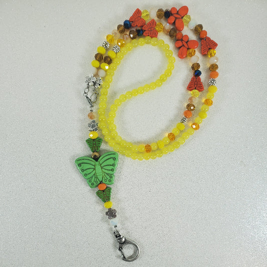 Beaded lanyard with butterfly charm on a white background