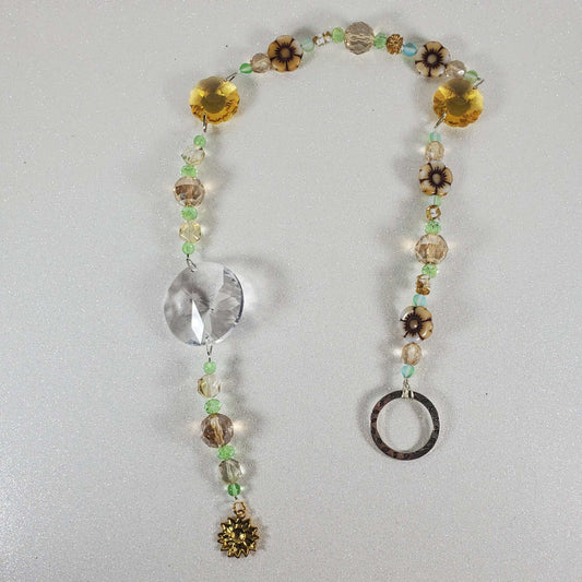 Sunflower crystal suncatcher with clear prism, topaz flower prisms, white glass flowers, green beads, and brass sunflower charm