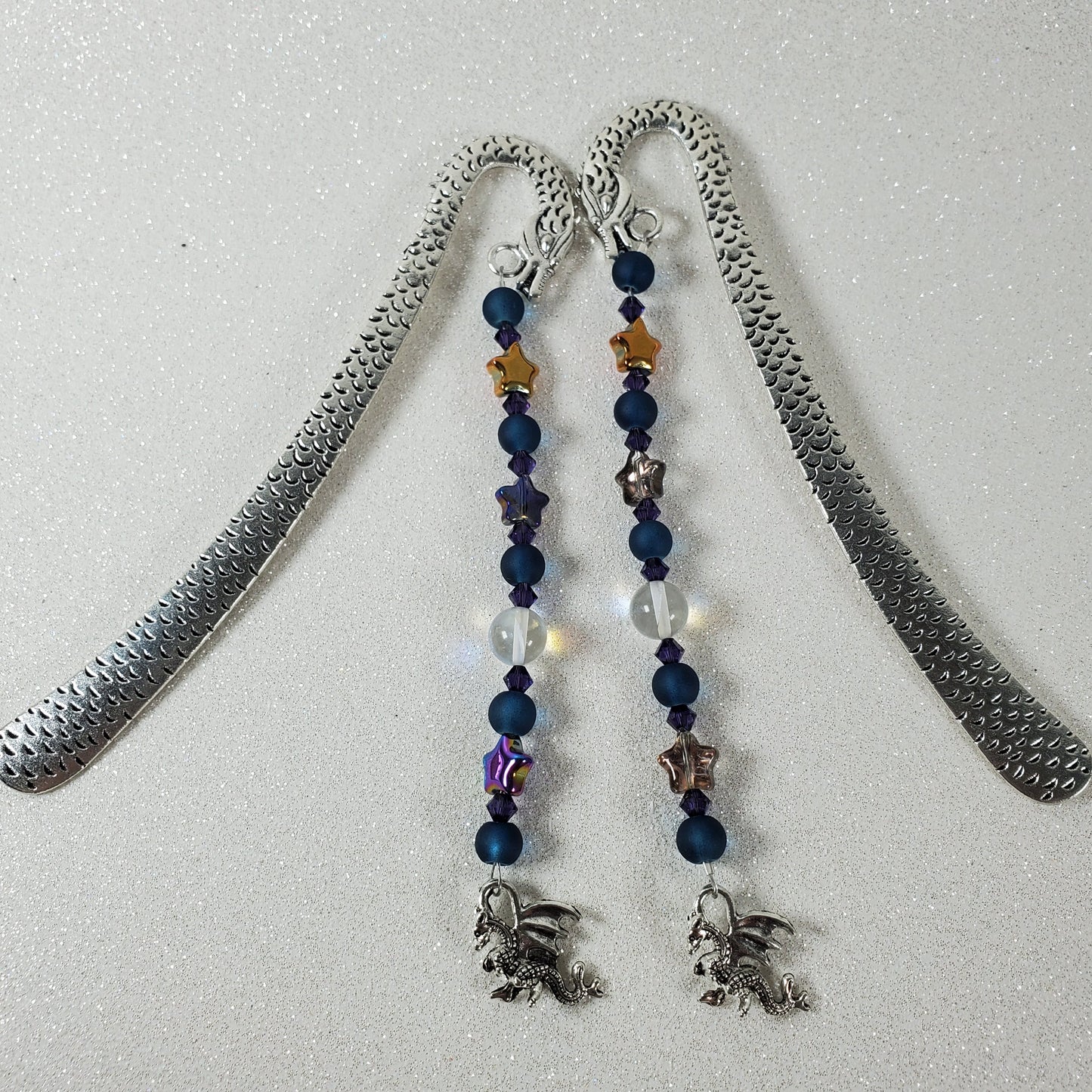 Bookmark with beaded chain and silver pendant on a light gray background