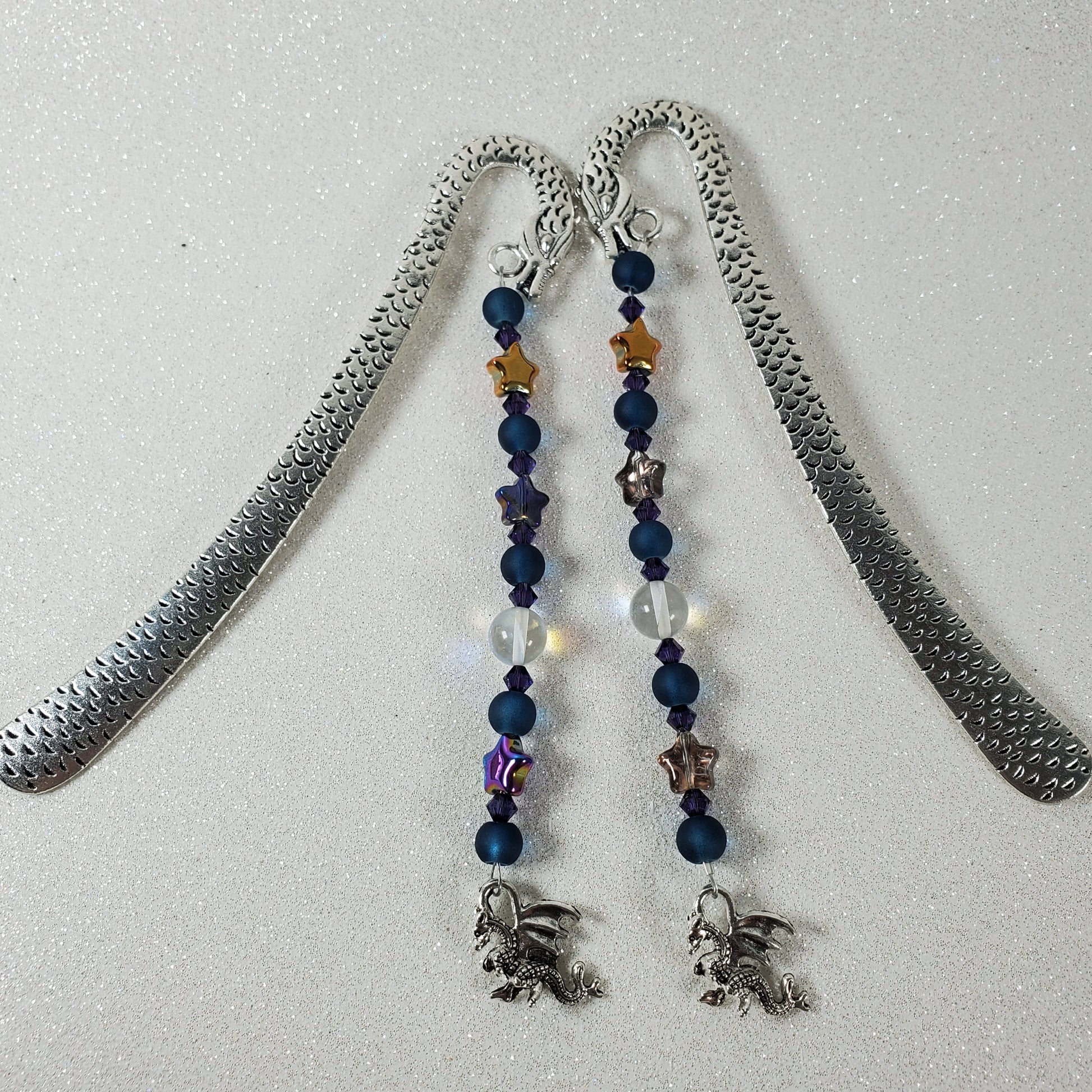 Bookmark with beaded chain and silver pendant on a light gray background