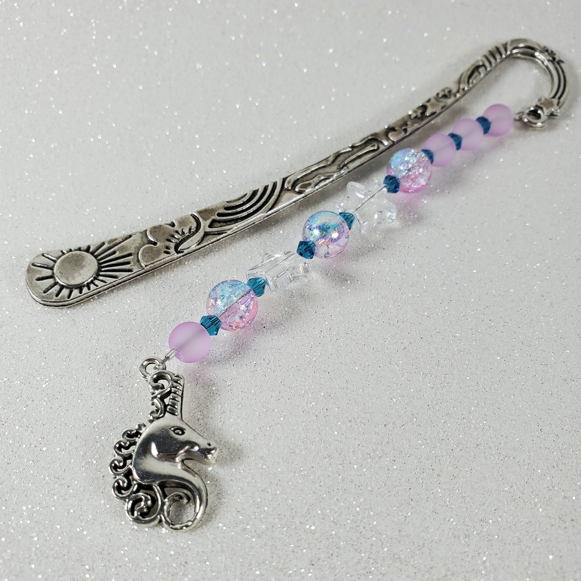 Decorative bookmark with beads and a small animal charm on a light gray background
