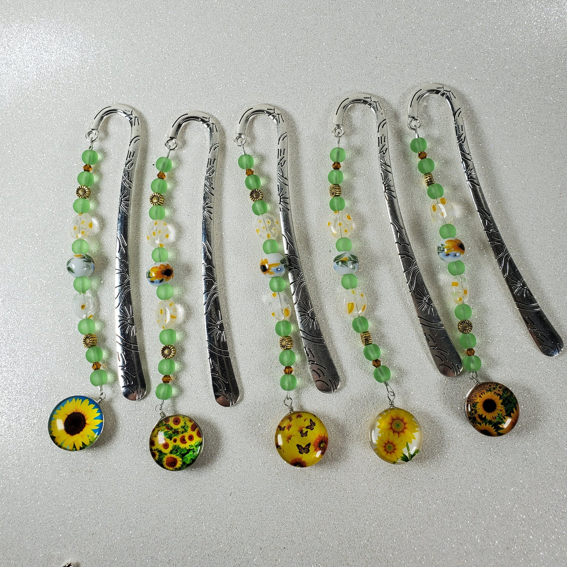 Set of decorative bookmarks with beads and floral designs on a light gray background