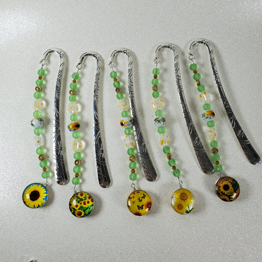 Set of decorative bookmarks with beads and floral designs on a light gray background
