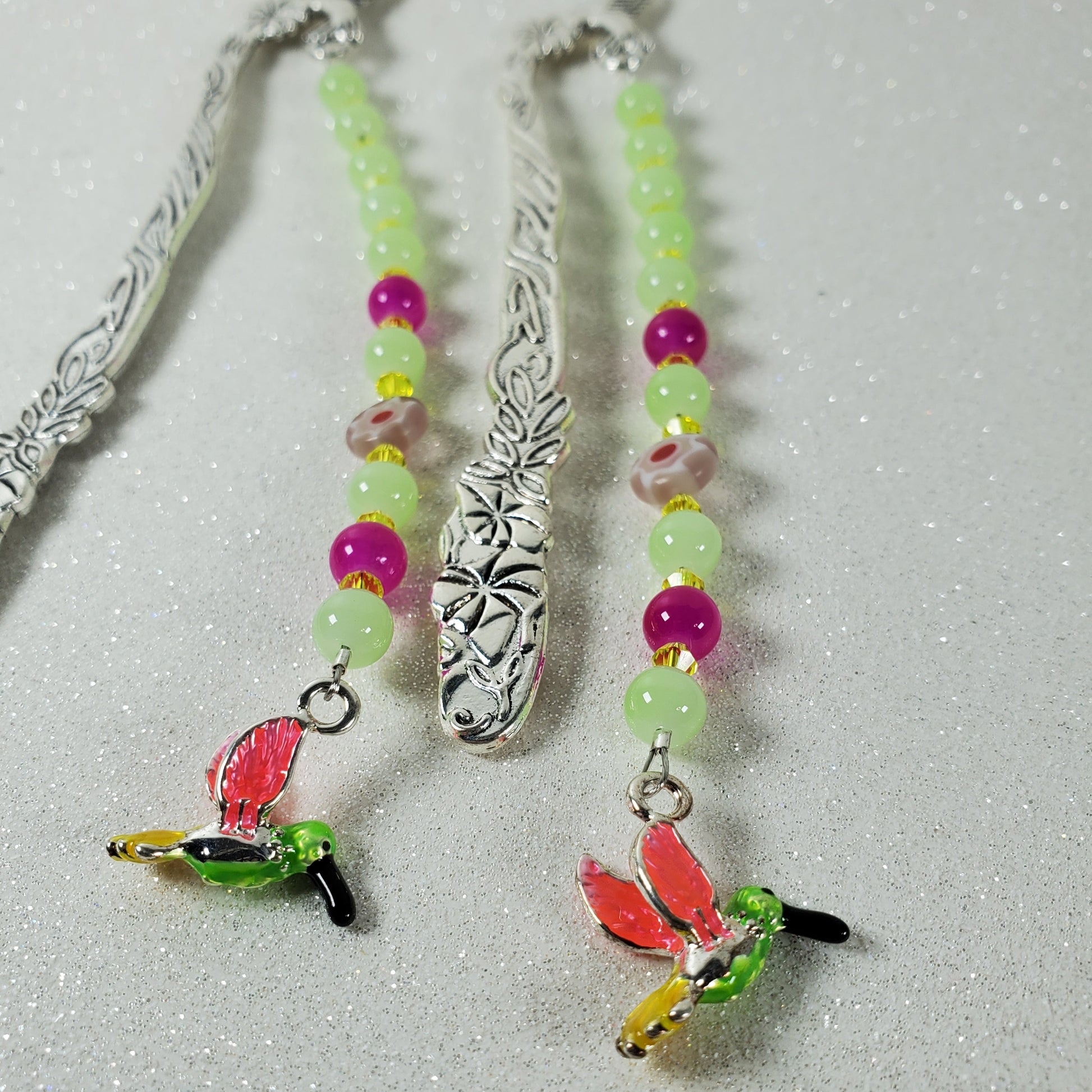Colorful beaded bookmark with hummingbird charm on a light gray background