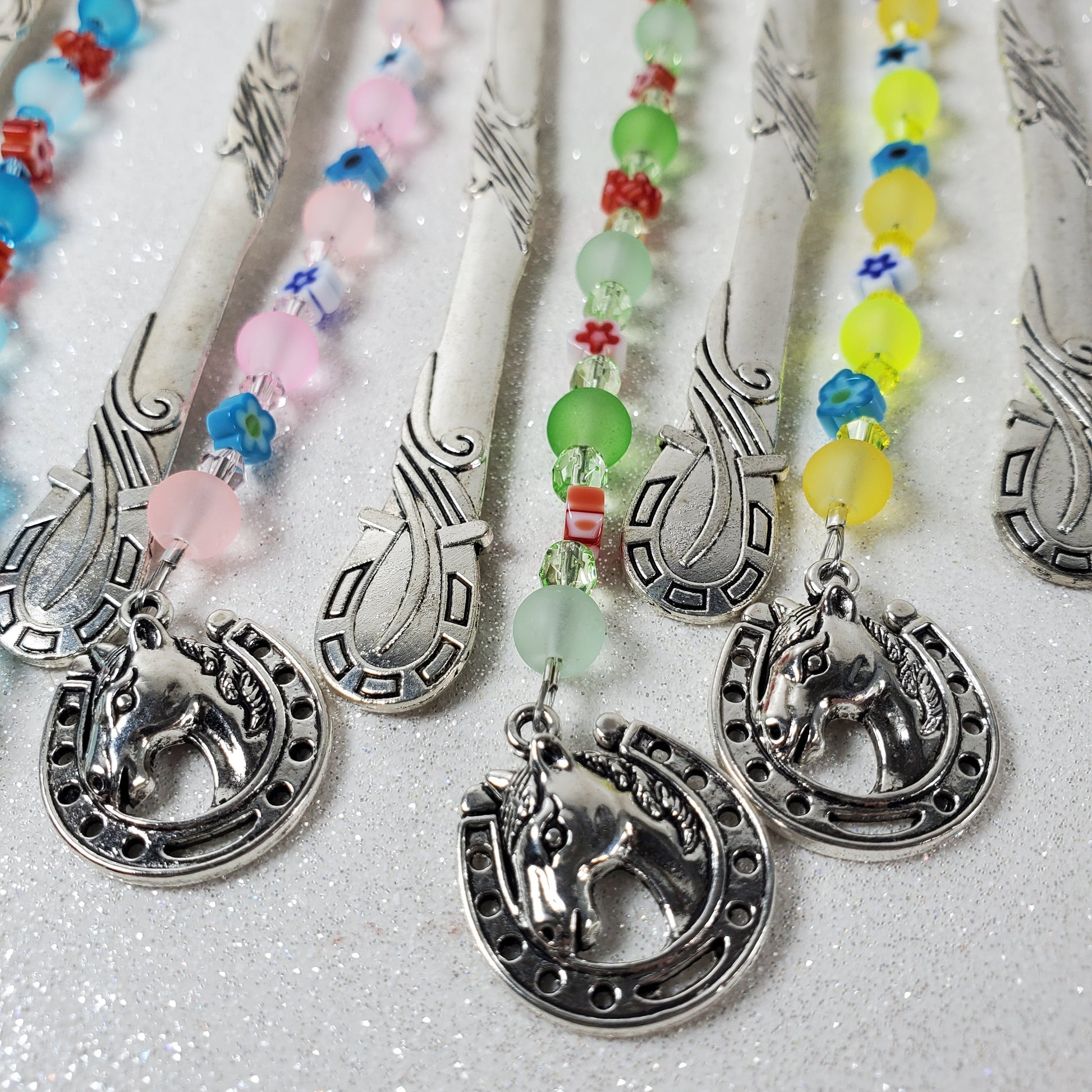 Decorative bookmarks with colorful beads and silver horse head designs on a white background.
